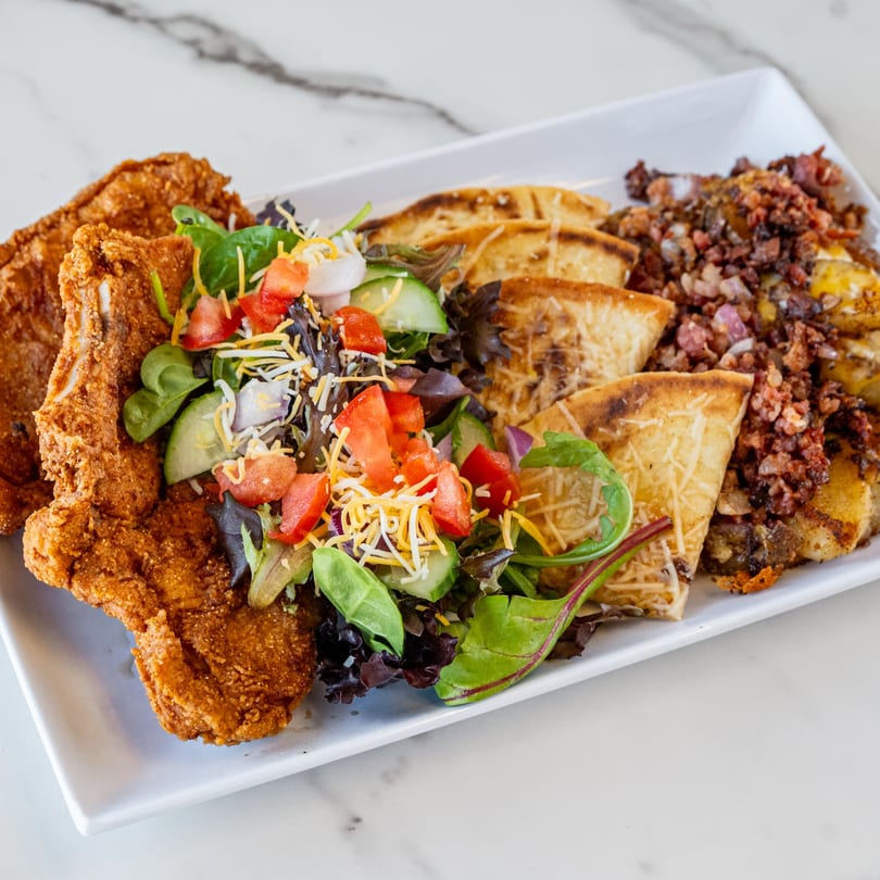 Urban Grill's fried chicken, side salad, cheesy flatbread, and breakfast potatoes with bacon.